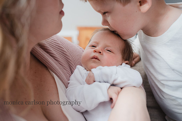 Big brother kissing his new baby sister in Alpharetta