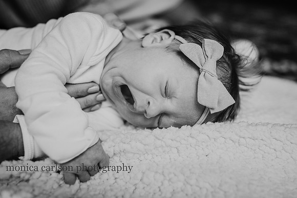 Newborn girl yawing on a bed a home in georgia