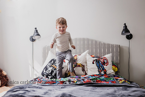 Boy jumping on his bed at a home photo session in alpharetta