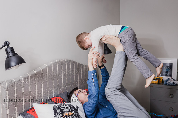 Father and son playing airplane during a in home photo session