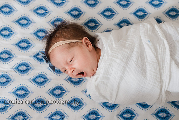 Photo of a sweet baby yawning in her crib by monica carlson photography