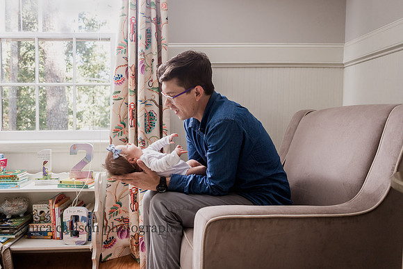 father looking at his new baby in his home in alpharetta, georgia