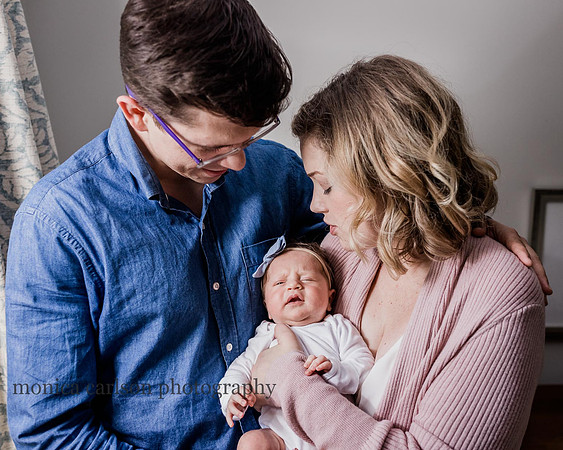 mother and father holding their baby at home during a photo session with Monica carlson