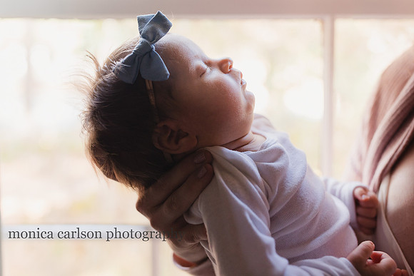 portrait of a sleeping newborn in its mothers arms by monica caralson