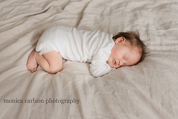 sweet newborn sleeping on her parents bed in alpharetta, georgia