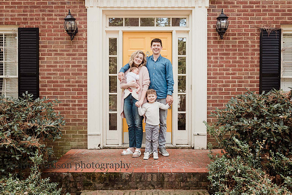portrait of a happy family in front of a yellow door in georgia