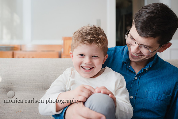 Dad and his son laughing on the couch at home