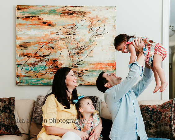 two year being held up by dad while family looks on by monica carlson