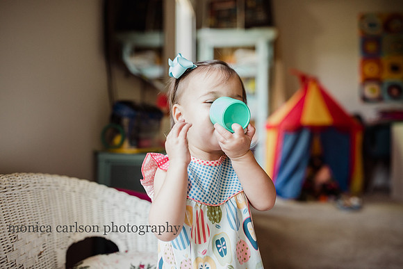 little girl pretending to drink from a toy cup in her home in alpharetta