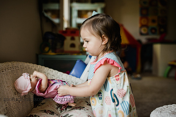two year old girl playing with her baby dolls at home in Alpharetta