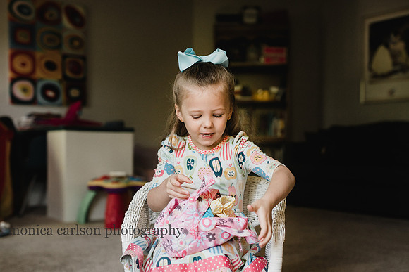 little girl playing with her dolls during a home lifestyle photo session