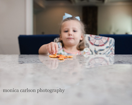 girl eating goldfish in her home kitchen