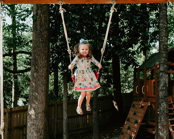 Girl on a swing outside during a lifestyle session with Monica carlson