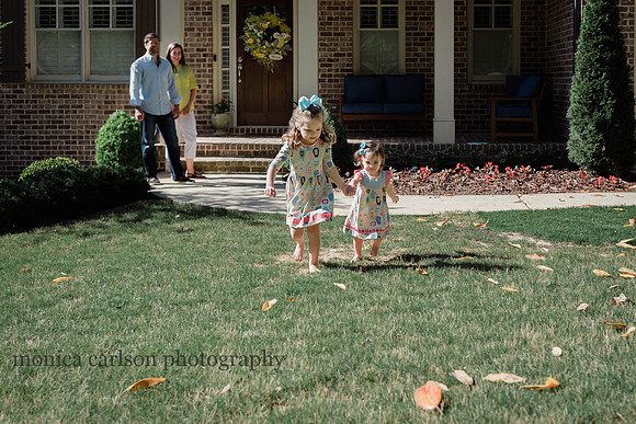 two sisters running in front of their home in Alpharetta while their parents watch