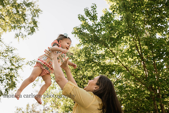 girl being tossed in the air by her mother during a family photo session