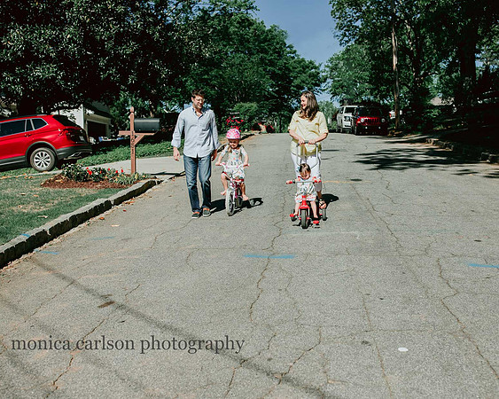 family outside their home taking a bike ride during a home photography session