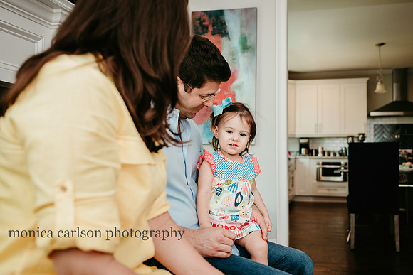 father holding his daughter in their living room