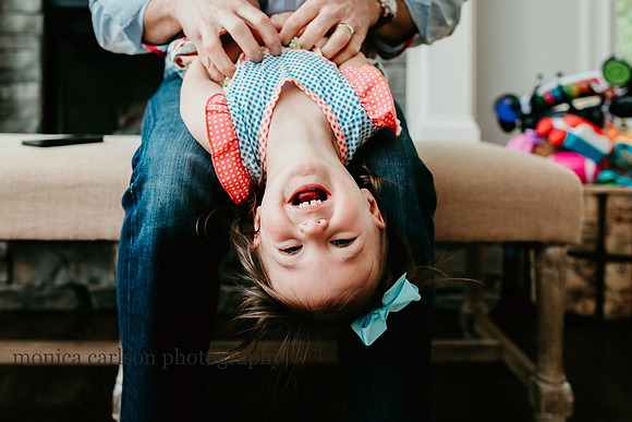 upside photo of a girl being tickled by her father by monica carlson