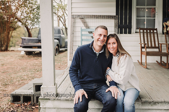husband and wife sitting on a white wooden porch