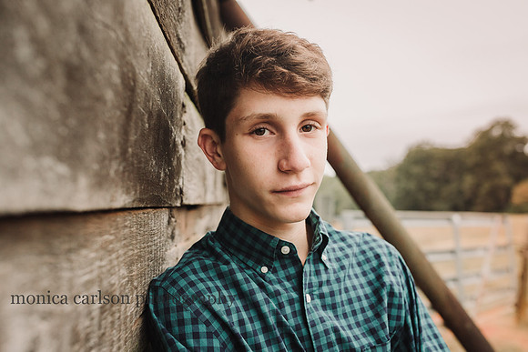 portrait of a young man by a barn in cumming, ga