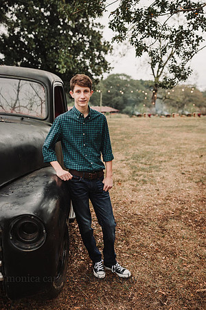 brunette boy leaning against a pick up truck at Milforf family farm