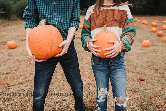 teens holding pumpkins in front of their stomach