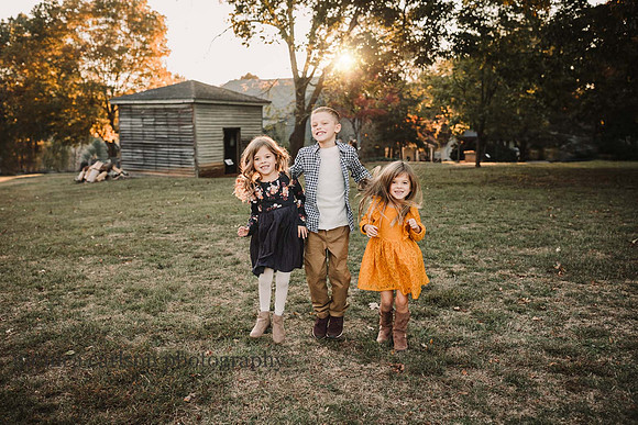 three funny siblings dancing during a photo session with monica carlson
