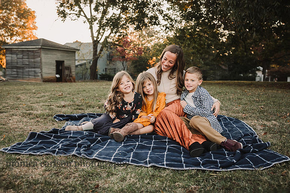 Portrait of a mother sitting on a blanket with her three children taken by monica carlson