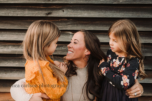 mother looking at her daughter adoringly during a photo session with Monica Carlson