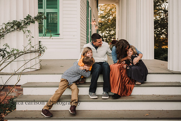 Family hugging while seated on the steps of barrington hall