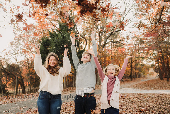 three siblings having fun throwing leaves during a session with monica carlson photography