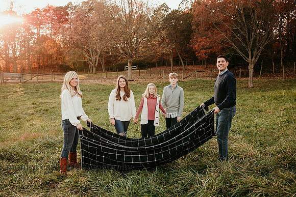 family of five get ready to play a game with a blanket