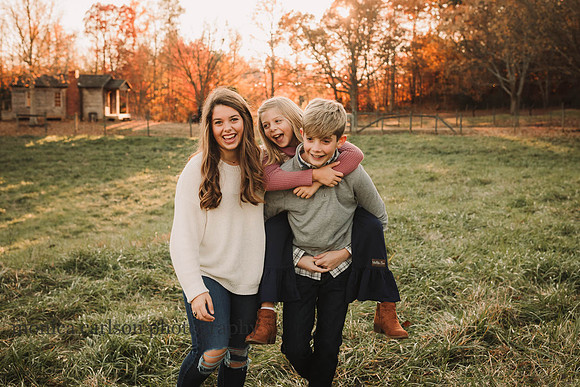 younger sister ride piggy back with her brother while teenage sister walks besides them