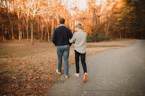 dad and his teenage son walking arm in arm during a photo session