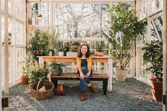 Little girl sitting in a greenhouse at Prospect farms