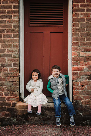 brother and sister sitting in front of a red door at Barrington Hall