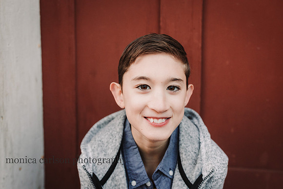 portrait of tween boy with a red back ground
