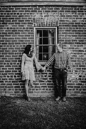 husband and wide holding hands and looking at each other in front of the ice house on the barrington hall grounds