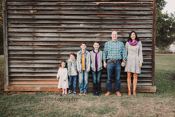 family standing in front of the wooden fire house at Barrington Hall