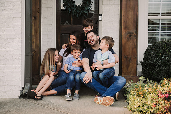 family laughing on their front porch together