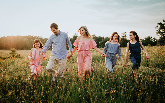 family taking a walk through a wild flower field taken by monica carlson photography