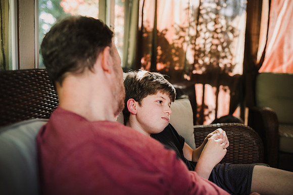 boy and father sharing a funny moment on a home patio