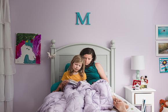 mother and daughter reading in a child's bedroom