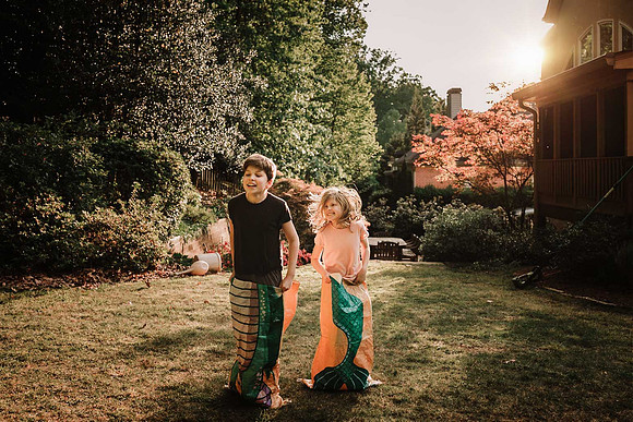 teen boy and his little sister having a back yard sack race