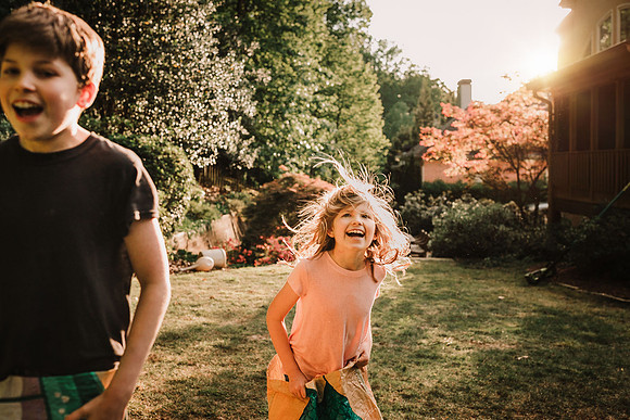 girl and brother laughing together after a sack race