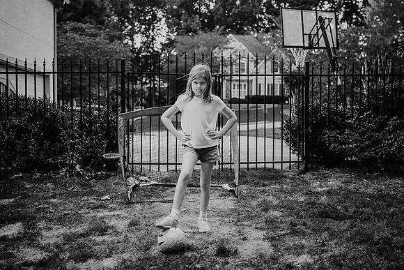 little girl looking tough in front of soccer net