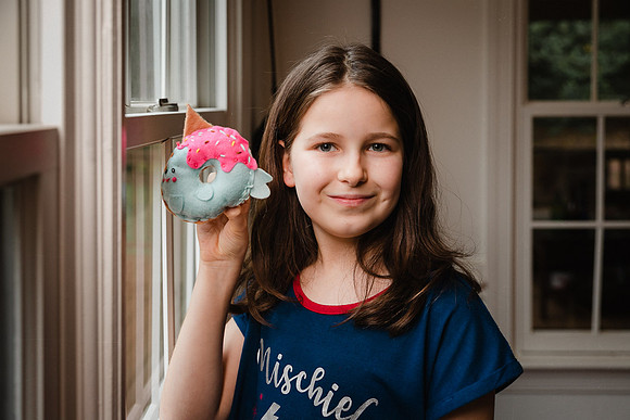 little girl proudly showing off her felt donuts craft