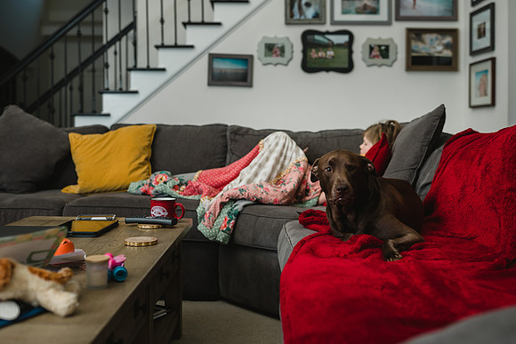 dog and girl laying on a couch