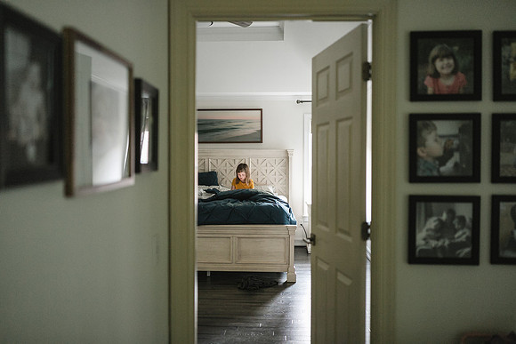 girl sitting on a large bed looking at her ipad