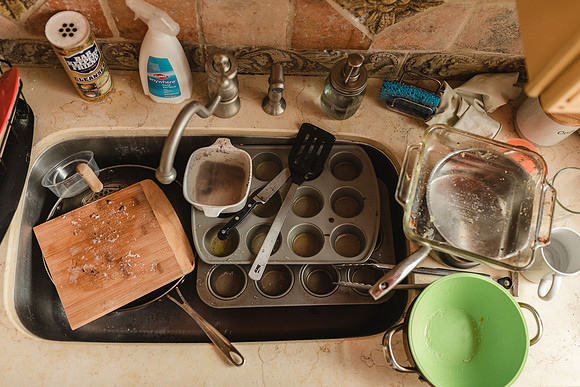 messy sink full of dishes from above